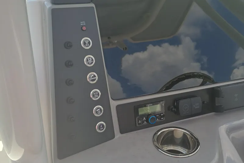 Slide: The Image of 2025 Robalo R230 Center Console dashboard with control panel and steering wheel reflection. - 14