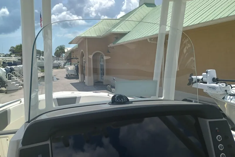 Slide: The Image of 2025 Robalo R230 Center Console boat dashboard with clear windshield and marina background. - 15