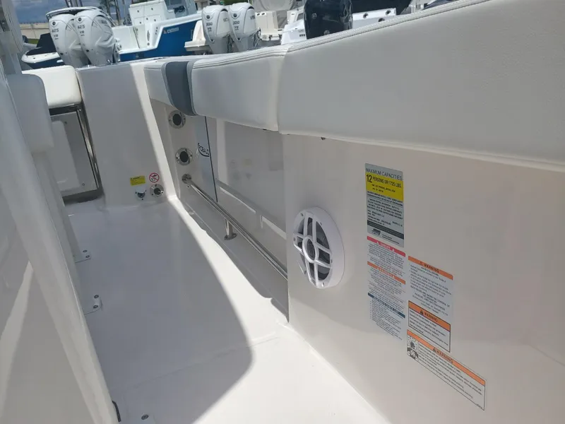 Slide: The Image of 2025 Robalo R230 Center Console interior with seating and safety labels. - 29