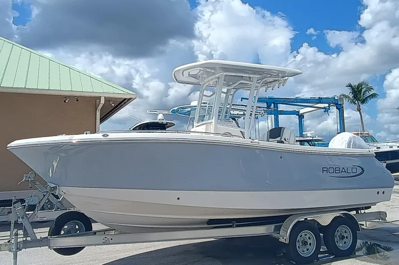 Slide: The Image of 2025 Robalo R230 Center Console boat on trailer under blue sky. - 3