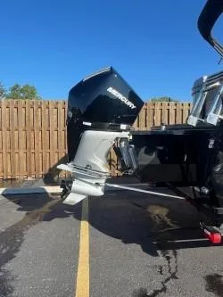 Slide: The Image of 2024 Regency 250 LE3 boat with Mercury outboard motor in parking lot. - 2