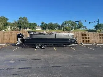 Slide: The Image of 2024 Regency 250 LE3 pontoon boat parked in a lot, clear sky background. - 3