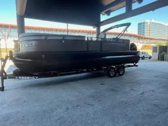 Slide: The Image of 2024 Regency 250 LE3 pontoon boat on trailer under shelter. - 6