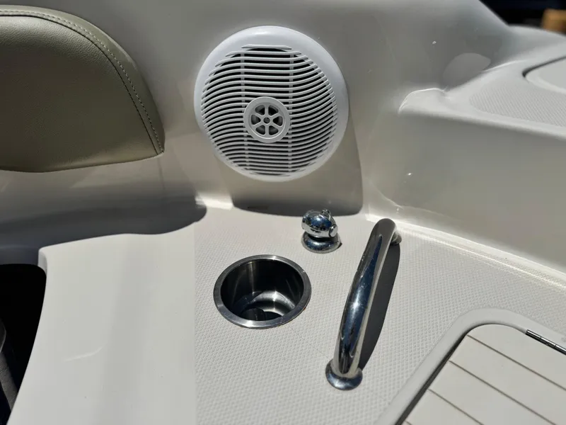 Slide: The Image of 2005 Sea Ray 240 Sundeck interior with speaker, cup holder, and handrail. - 11