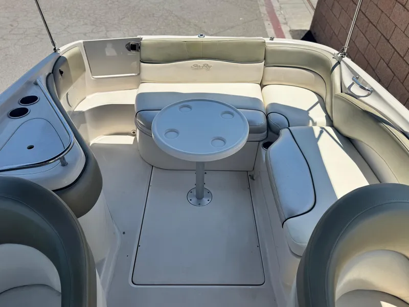 Slide: The Image of 2005 Sea Ray 240 Sundeck interior with seating and round table. - 15