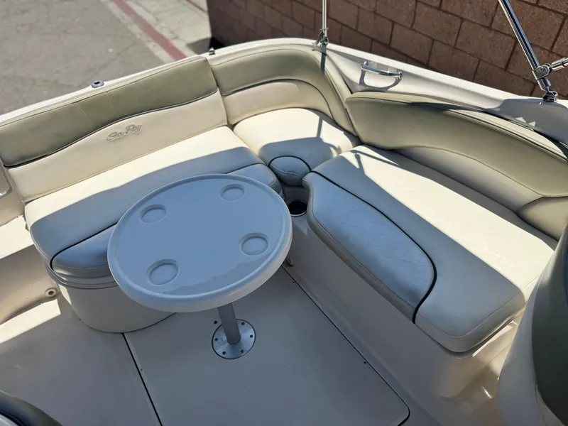 Slide: The Image of 2005 Sea Ray 240 Sundeck interior with seating and round table. - 16