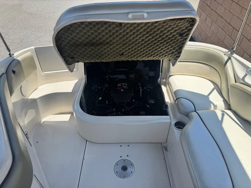 Slide: The Image of 2005 Sea Ray 240 Sundeck boat engine compartment with open hatch and seating area. - 20