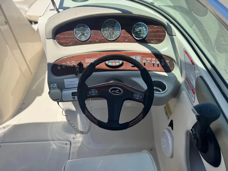 Slide: The Image of 2005 Sea Ray 240 Sundeck dashboard with steering wheel and instrument panel. - 26