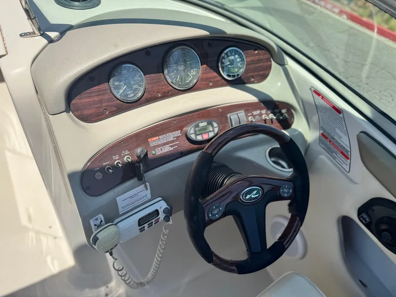 Slide: The Image of 2005 Sea Ray 240 Sundeck dashboard with gauges, steering wheel, and control panel. - 27