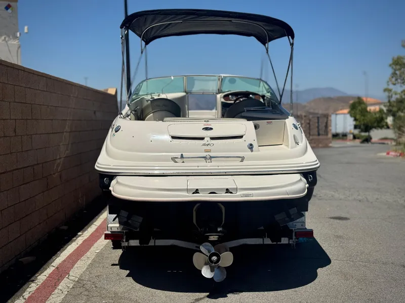 Slide: The Image of 2005 Sea Ray 240 Sundeck boat with canopy, parked on a sunny day. - 4