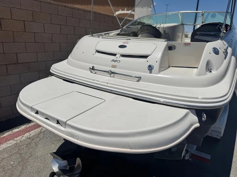Slide: The Image of 2005 Sea Ray 240 Sundeck boat, rear view, parked on a trailer near a brick wall. - 6