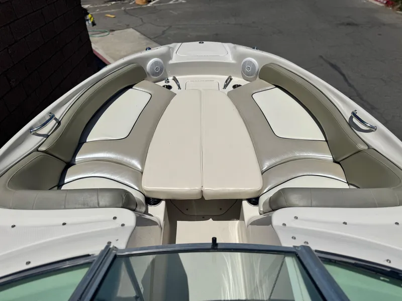 Slide: The Image of 2005 Sea Ray 240 Sundeck boat interior with cushioned seating and table. - 9