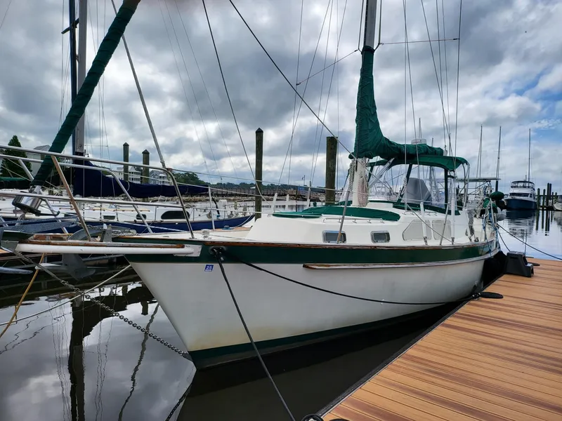 Slide: The Image of 1983 Irwin 38 Center Cockpit sailboat docked at a marina under cloudy skies. - 1
