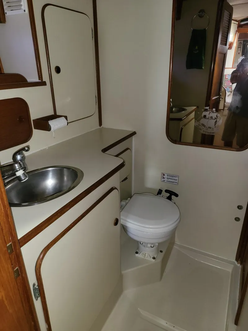 Slide: The Image of 1983 Irwin 38 Center Cockpit bathroom with sink, toilet, and mirror. - 16