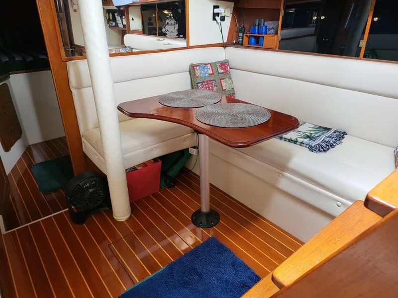 Slide: The Image of Interior of 1983 Irwin 38 Center Cockpit with cozy seating and wooden table. - 2