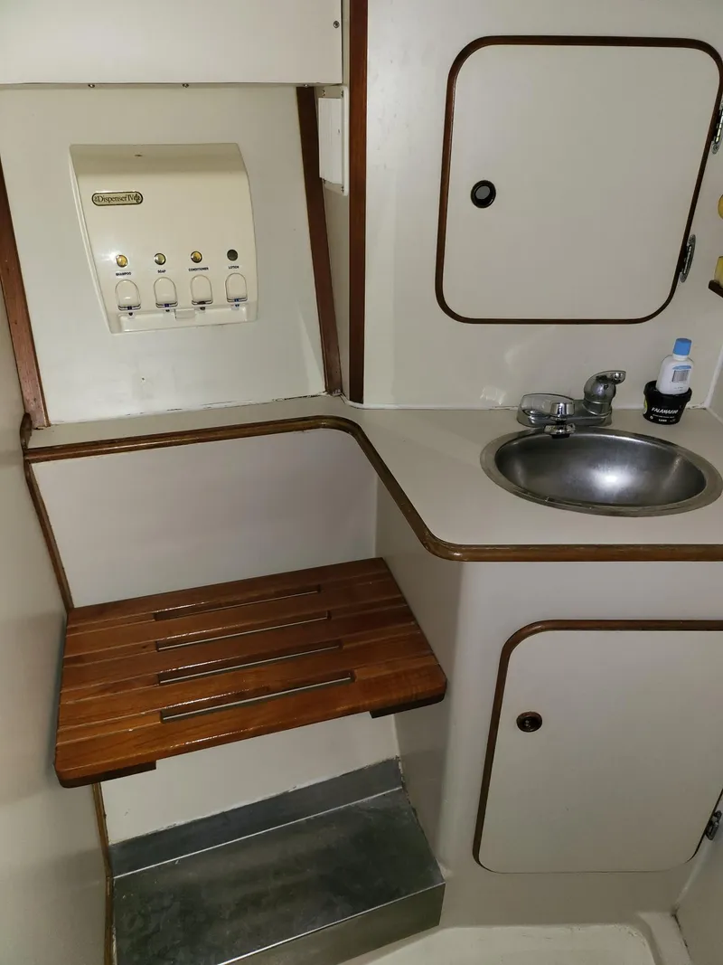 Slide: The Image of 1983 Irwin 38 Center Cockpit bathroom with sink, wooden seat, and storage cabinets. - 28