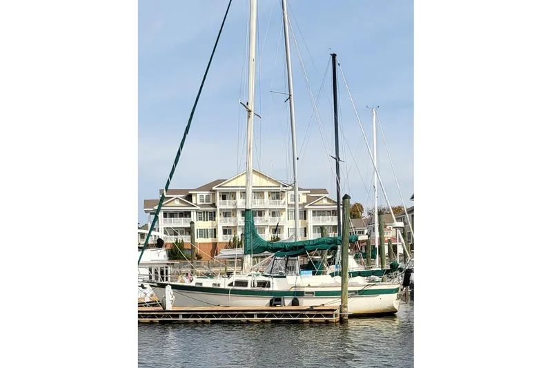 Slide: The Image of 1983 Irwin 38 Center Cockpit sailboat docked near waterfront buildings. - 34