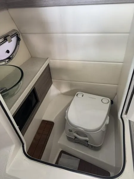 Slide: The Image of 2019 Regal 2800 boat interior with compact toilet and modern sink. - 10