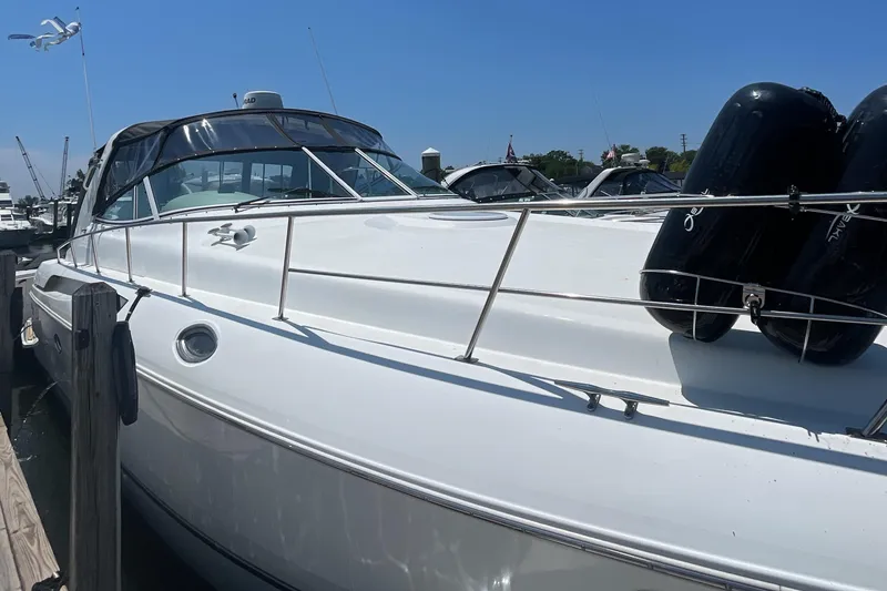 Slide: The Image of 2000 Cruisers Yachts 3870 Express docked, featuring sleek white design and black fenders. - 11