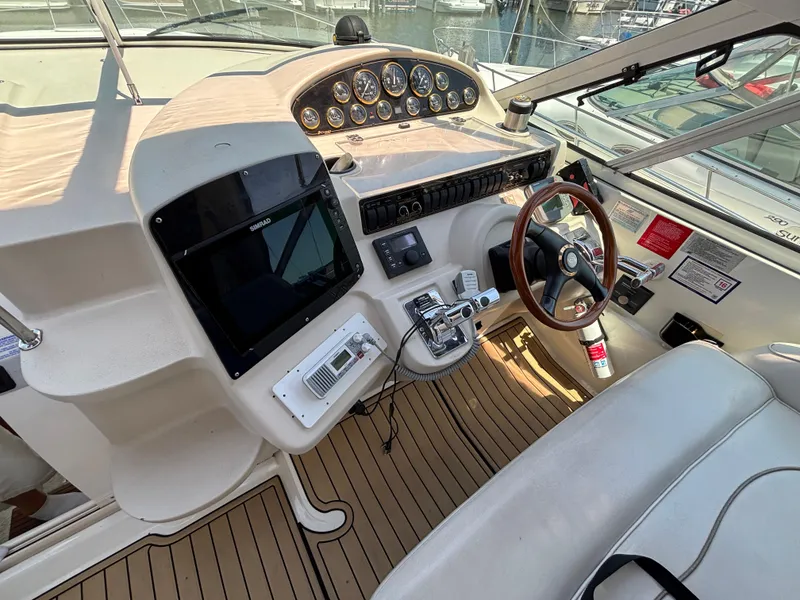 Slide: The Image of 2000 Cruisers Yachts 3870 Express helm with steering wheel, controls, and navigation equipment. - 20
