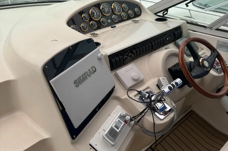 Slide: The Image of 2000 Cruisers Yachts 3870 Express helm with Simrad navigation and wood steering wheel. - 21