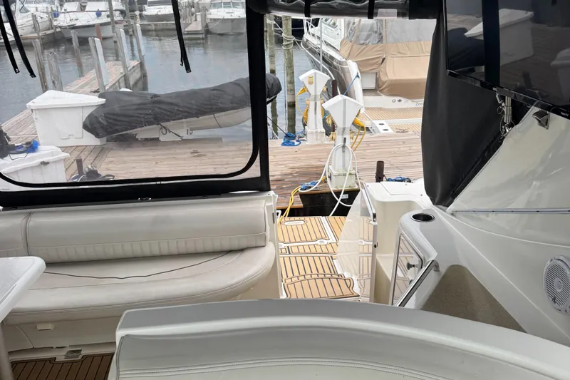 Slide: The Image of 2000 Cruisers Yachts 3870 Express interior with dock view, featuring seating and marine equipment. - 22