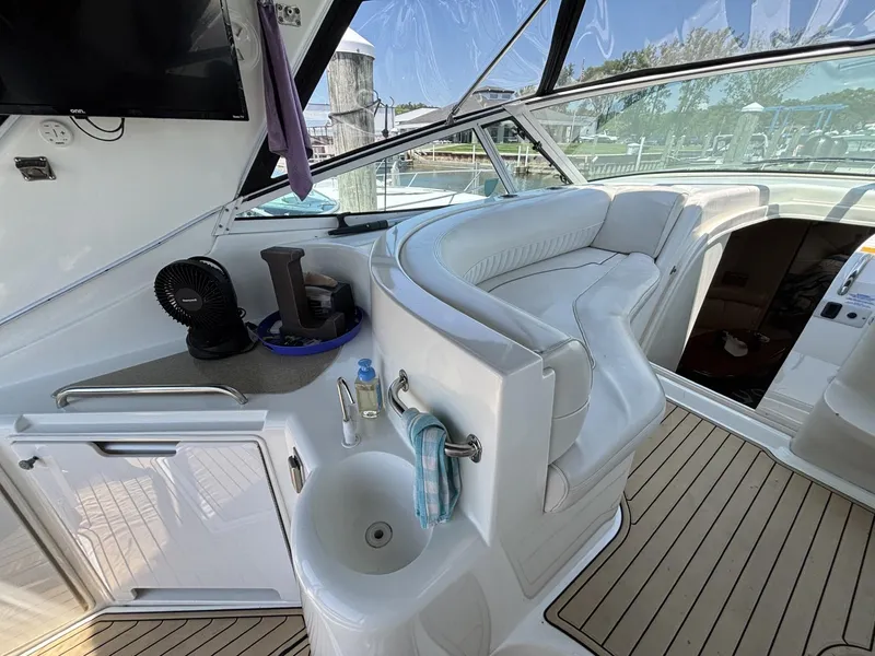 Slide: The Image of 2000 Cruisers Yachts 3870 Express interior with seating, sink, and fan on deck. - 24