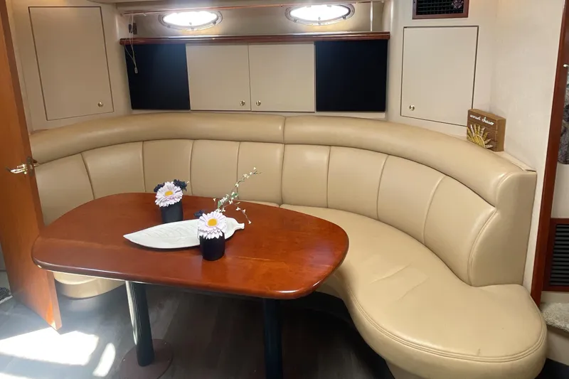 Slide: The Image of Luxurious interior of 2000 Cruisers Yachts 3870 Express with curved seating and wooden table. - 27