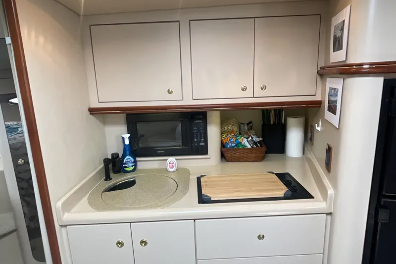 Slide: The Image of 2000 Cruisers Yachts 3870 Express galley with sink, microwave, and storage cabinets. - 29