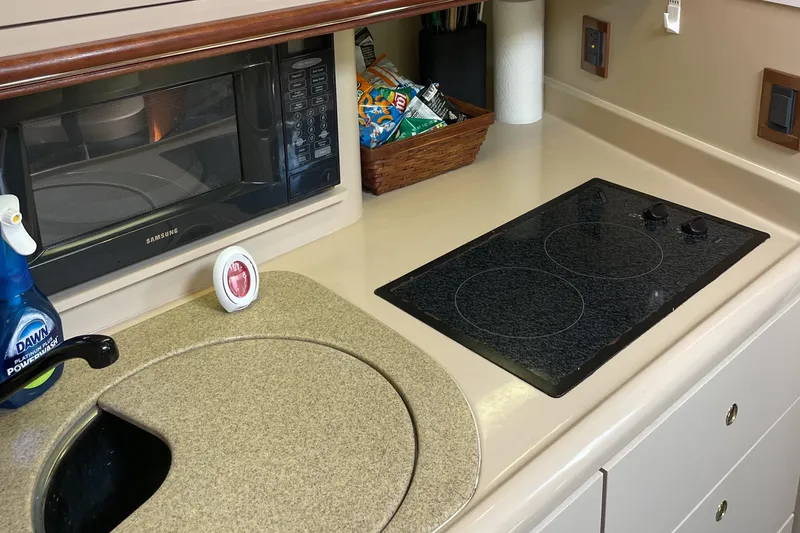 Slide: The Image of 2000 Cruisers Yachts 3870 Express kitchen with stove, microwave, and sink. - 31
