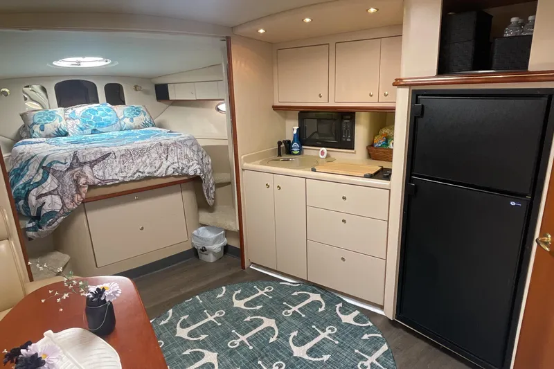 Slide: The Image of 2000 Cruisers Yachts 3870 Express interior with bed, kitchenette, and nautical decor. - 35
