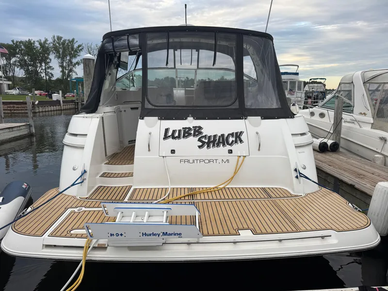 Slide: The Image of 2000 Cruisers Yachts 3870 Express docked, featuring a spacious deck and custom nameplate. - 4