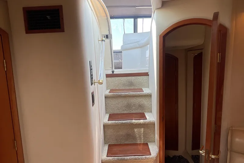 Slide: The Image of Interior stairs of 2000 Cruisers Yachts 3870 Express, featuring wood accents and carpeted steps. - 46