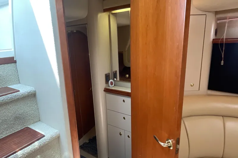 Slide: The Image of Interior of 2000 Cruisers Yachts 3870 Express, featuring stairs, wood cabinetry, and seating. - 49