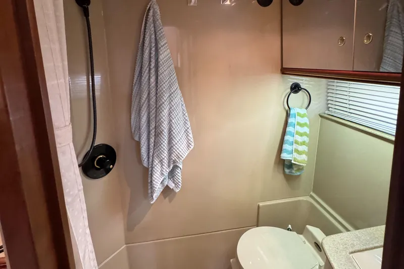 Slide: The Image of Bathroom interior of 2000 Cruisers Yachts 3870 Express with towels and shower. - 57