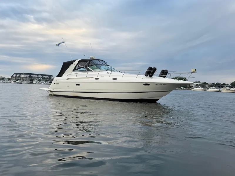 Slide: The Image of 2000 Cruisers Yachts 3870 Express on calm water under cloudy sky. - 6