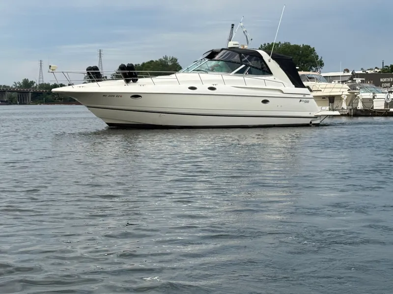 Slide: The Image of 2000 Cruisers Yachts 3870 Express boat docked on calm water. - 7