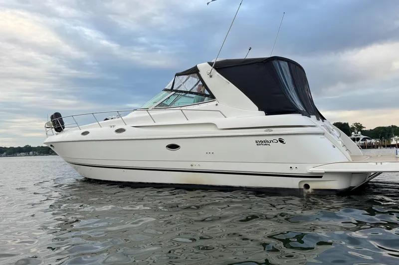 Slide: The Image of 2000 Cruisers Yachts 3870 Express on calm water under cloudy sky. - 8