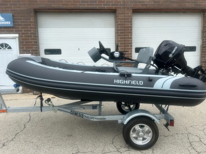 The Image of 2025 Highfield Classic 310 FCT inflatable boat on Genesis trailer, parked outside. - 0