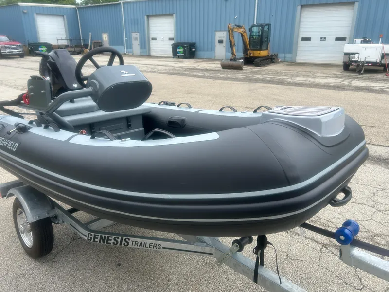 Slide: The Image of 2025 Highfield Classic 310 FCT inflatable boat on Genesis trailer, parked outside industrial building. - 10