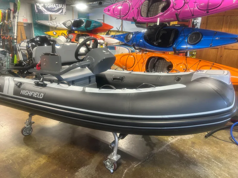 Slide: The Image of 2025 Highfield Classic 310 FCT inflatable boat displayed indoors with colorful kayaks. - 2