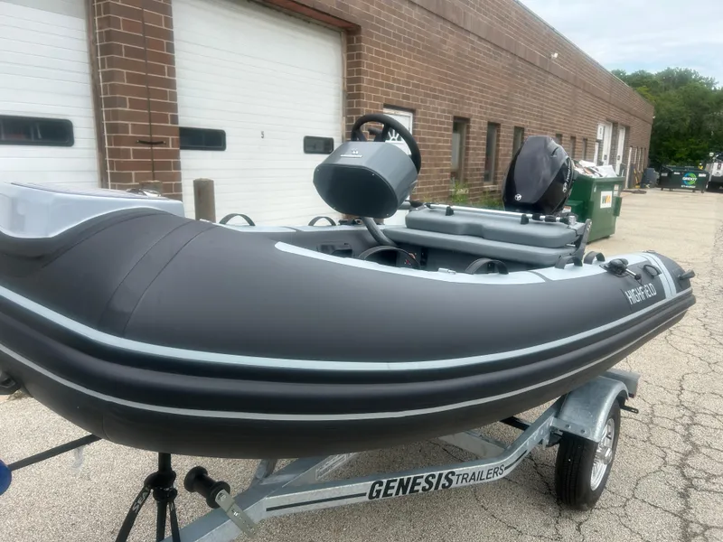 Slide: The Image of 2025 Highfield Classic 310 FCT inflatable boat on Genesis trailer, parked outside a brick building. - 9