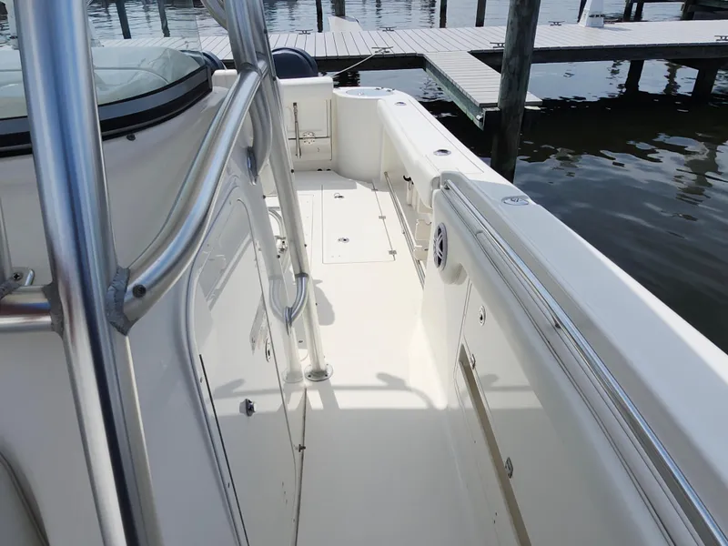 Slide: The Image of 2008 Robalo R300 Center Console boat deck with stainless steel railings at a marina. - 20