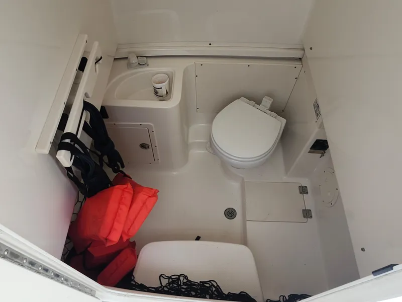 Slide: The Image of 2008 Robalo R300 Center Console boat interior with toilet and life jackets. - 27