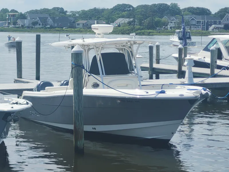 Slide: The Image of 2008 Robalo R300 Center Console boat docked at a marina with scenic background. - 4