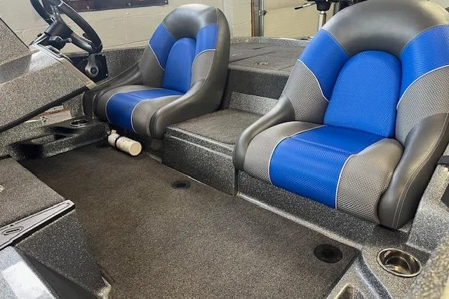 Slide: The Image of 2025 Ranger Z185 boat interior with blue and gray seats, steering wheel, and carpeted floor. - 71