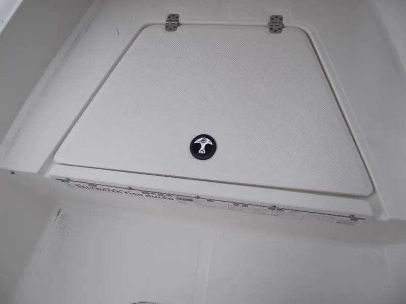 Slide: The Image of 2016 Key West 1720 Center Console storage compartment with textured lid and metal hinges. - 10