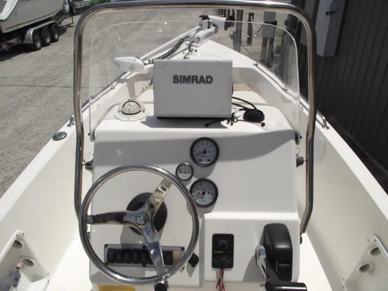 Slide: The Image of 2016 Key West 1720 Center Console boat dashboard with steering wheel and Simrad navigation system. - 17