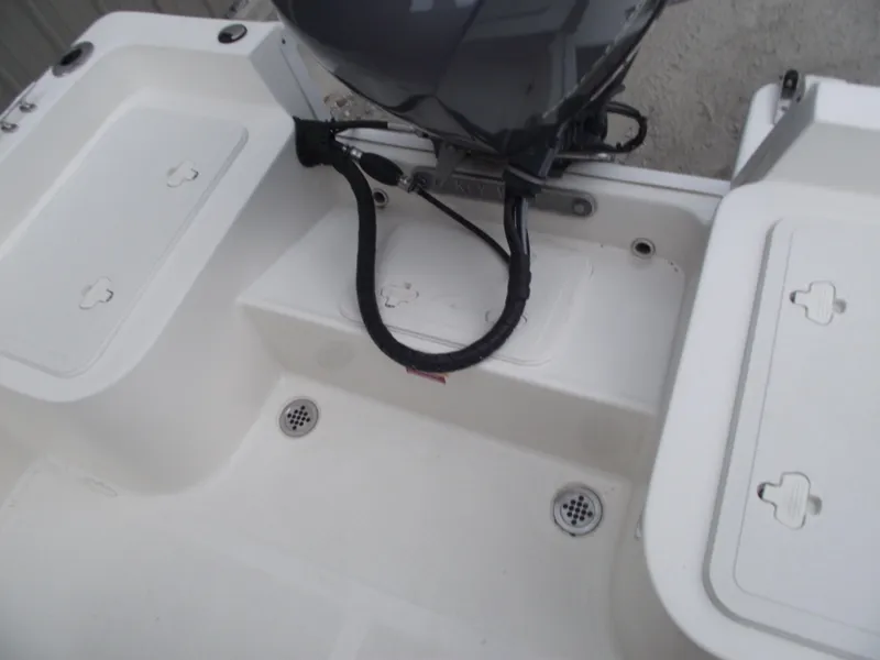 Slide: The Image of 2016 Key West 1720 Center Console boat interior with storage compartments and motor. - 25