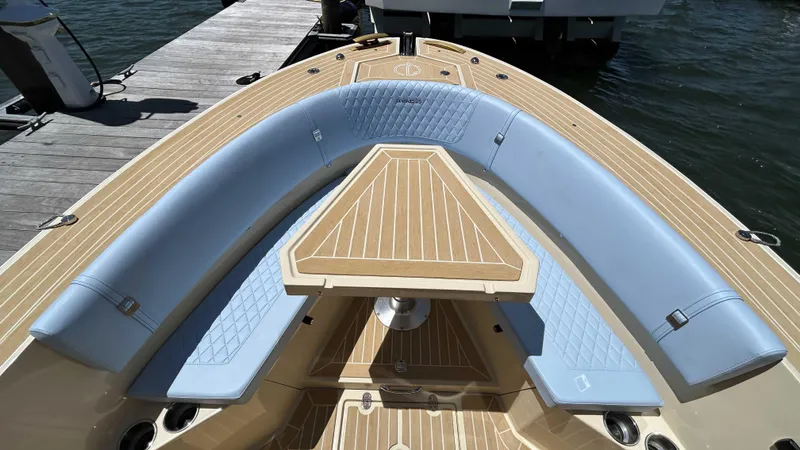Slide: The Image of Luxury Lilybaeum Levenzo 2025 boat with elegant seating and wooden deck at a dock. - 13